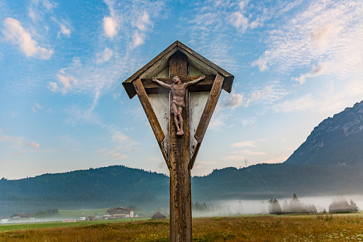 wooden crucifix in the tyrolean alps in morning time