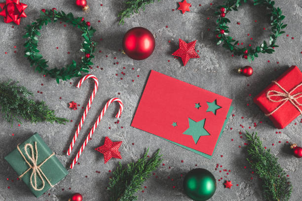 Christmas composition. Gifts, fir tree branches, envelope, card, red decorations on black background. Christmas, winter, new year concept. Flat lay, top view