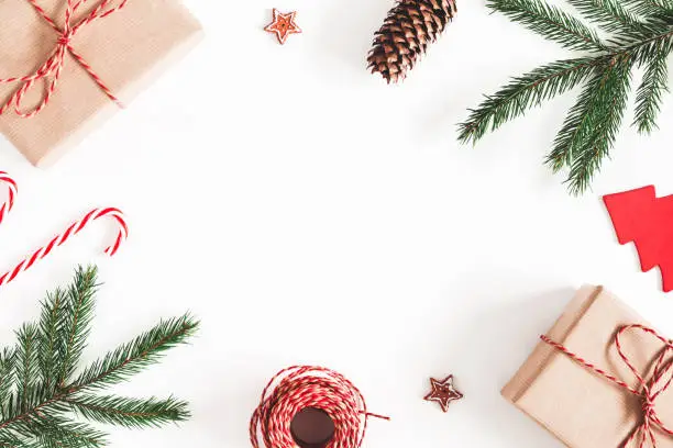 Photo of Christmas composition. Christmas gifts, fir tree branches, decorations on white background. Flat lay, top view, copy space