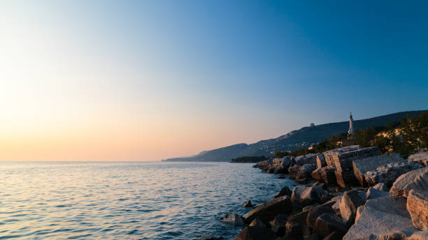 sunset at the beach below the lighthouse of Trieste, Friuli Venezia-Giulia, Italy