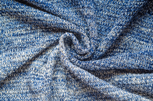 Blue Melange Yarn Sweater Twisted Background. Twisted in the center cloth swatch of knitted sweater