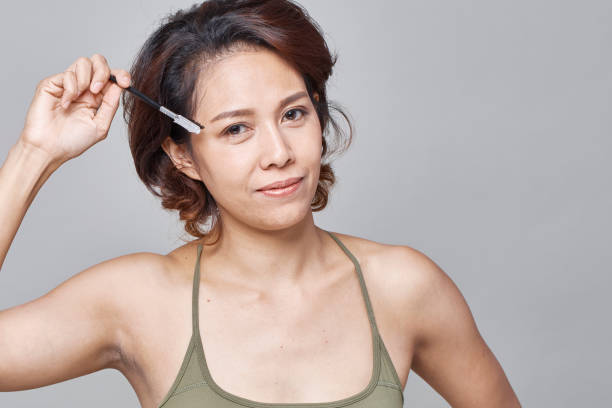 istock Closeup beautiful woman with eyebrow brush tool on gray 1071450532
