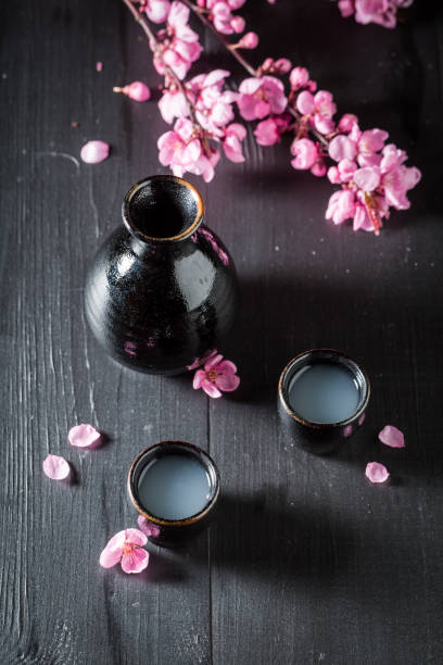istock Strong sake with blooming flowers on black table 1071451674