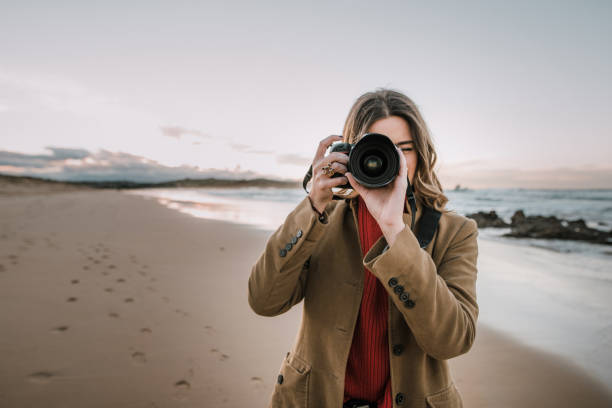 istock Young woman taking a picture with a modern DSLR camera 1071454968