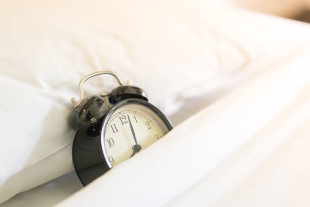 istock Metal Alarm clock on white bed 8 am. 1071461300