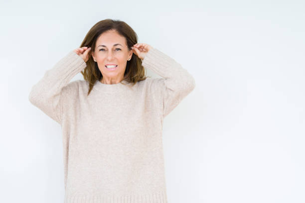 istock Beautiful middle age woman over isolated background Smiling pulling ears with fingers, funny gesture. Audition problem 1071461618