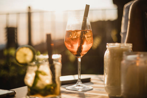 Time to Relax Two alcoholic drinks sitting on a table with a sunset in the background shining through. There are no people in the image with the drinks. building terrace stock pictures, royalty-free photos & images