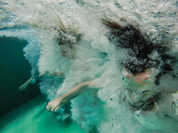 istock Friends Jumping into the Pool 1071462104