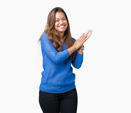 Young beautiful brunette woman wearing blue sweater over isolated background Clapping and applauding happy and joyful, smiling proud hands together