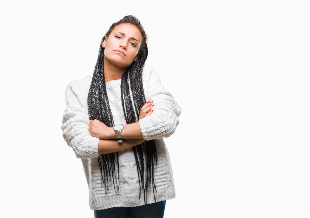 había trenzado de joven muchacha afroamericana pelo llevar suéter sobre escéptico de fondo aislado y nervioso, desaprobando la expresión en la cara con brazos cruzados. persona negativa. - anger child braids braided fotografías e imágenes de stock