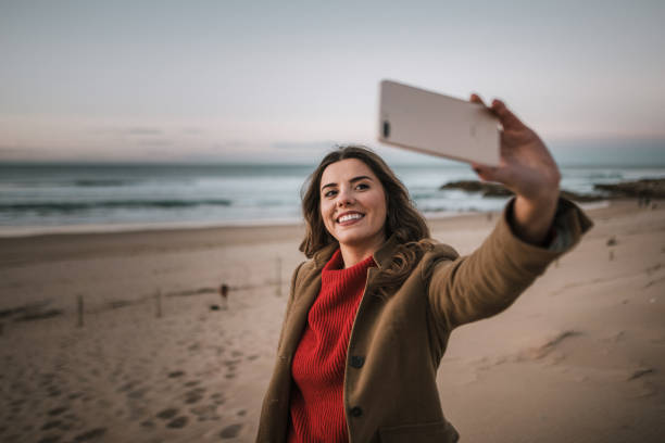 istock Young woman taking a selfie at a beach 1071468380