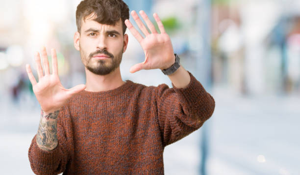 istock Young handsome man wearing winter sweater over isolated background Smiling doing frame using hands palms and fingers, camera perspective 1071468408