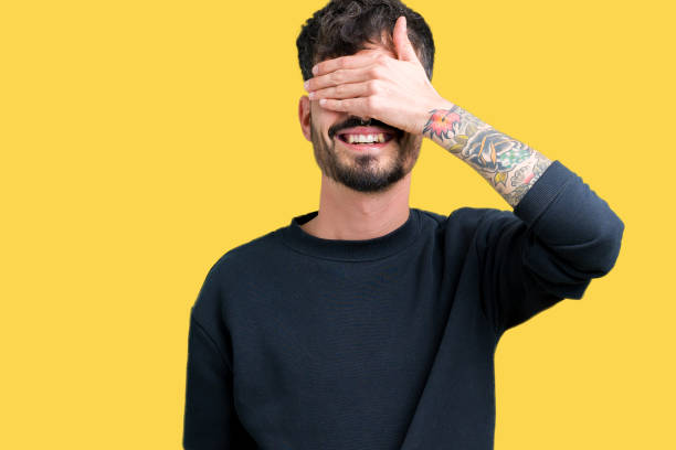 istock Young handsome man over isolated background smiling and laughing with hand on face covering eyes for surprise. Blind concept. 1071468926