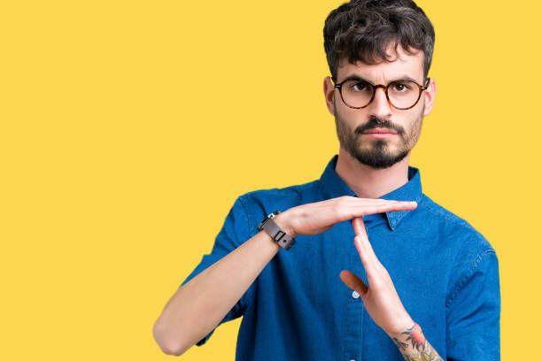 istock Young handsome man wearing glasses over isolated background Doing time out gesture with hands, frustrated and serious face 1071469046