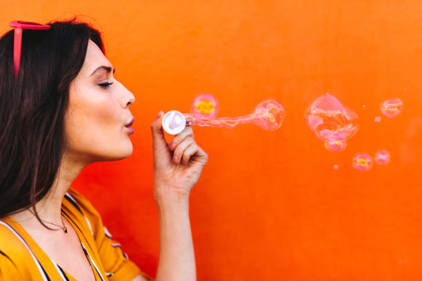 istock Beautiful woman blowing soap bubbles 1071470200