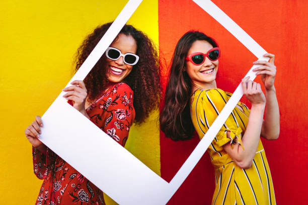 istock Beautiful women holding a blank photo frame 1071470454