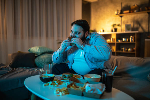 istock Overweight man eating hamburger 1071471086