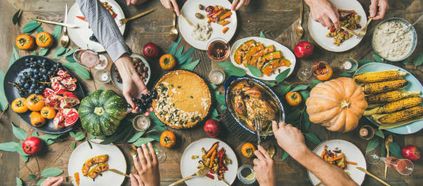 istock Friends feasting at Thanksgiving Day table with turkey, wide composition 1071471182
