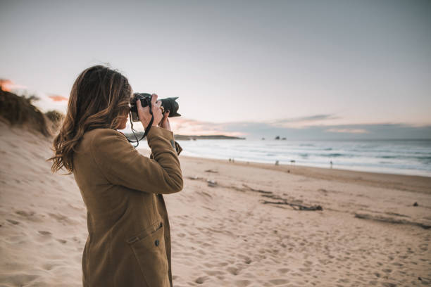 Young woman taking a picture with a modern DSLR camera