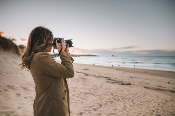 Young woman taking a picture with a modern DSLR camera Young woman taking a picture with a modern DSLR camera slr camera stock pictures, royalty-free photos & images