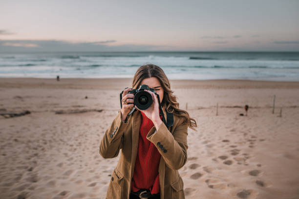 istock Young woman taking a picture with a modern DSLR camera 1071474384
