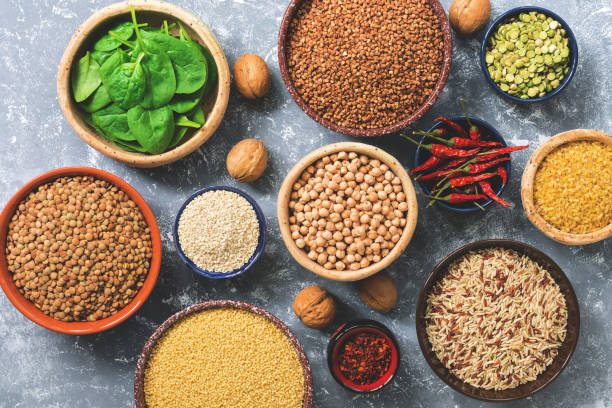 istock Vegetarian protein sources: legumes, cereals, spinach, spices, nuts. Healthy balanced meal. Top view, flat lay. 1071477416