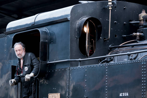 Uppsala, Sweden – July 22, 2018: Train conductor looking out of the window of a vintage carriage.