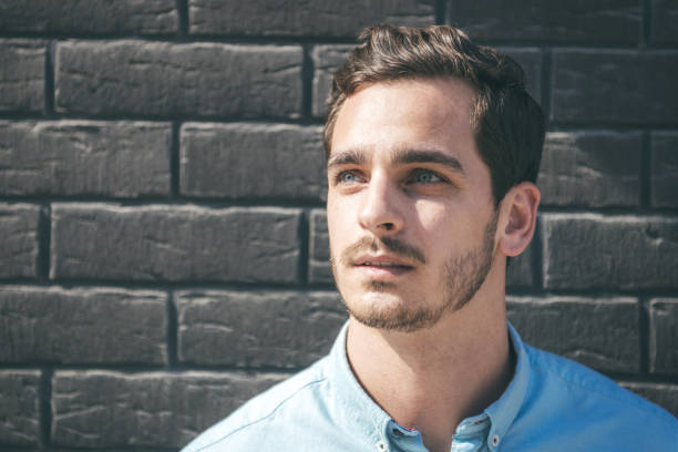 istock handsome young businessman in front of brick wall 1071500216