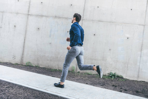 young businessman running outdoors in city