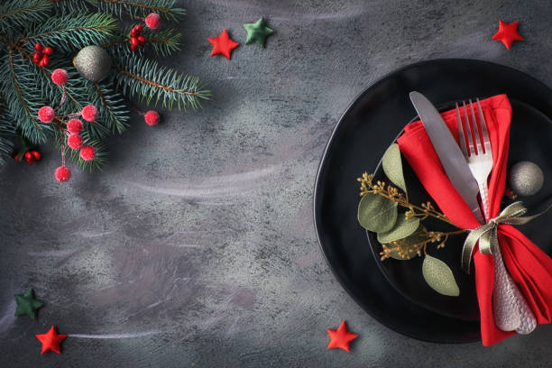 istock Christmas table setup with decorated dark plates and crockery on dark background with copy-space 1071502816