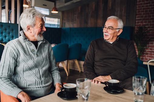 Joyful senior men having a conversation at coffee shop