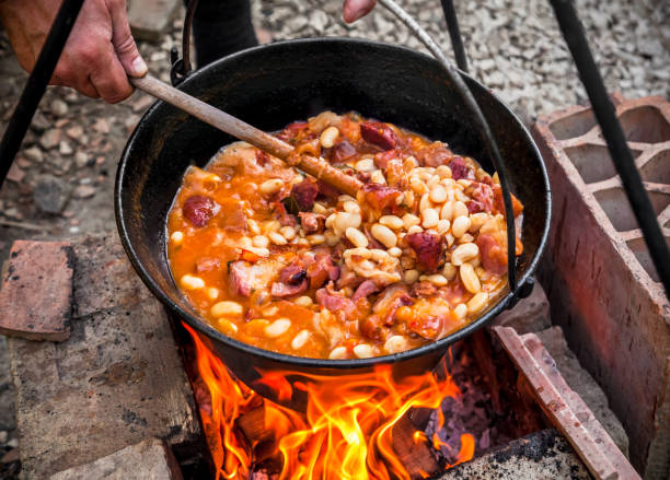 istock Cooking beans outdoors in black pot at picnic on fire 1071512824