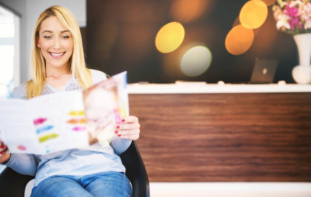 waiting on a beauty treatment. - reading newspaper 30s adult imagens e fotografias de stock