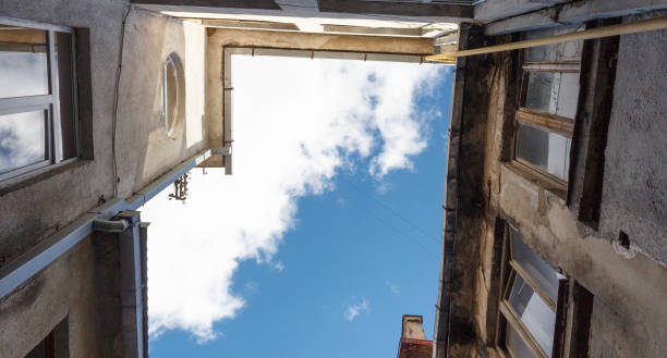Looking up at old building to sky with clouds in perspective view