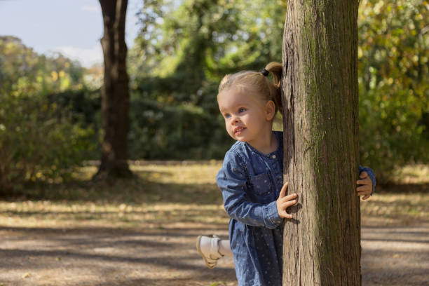 istock Beautiful Little Girl Hiding Behind A Tree 1071556974