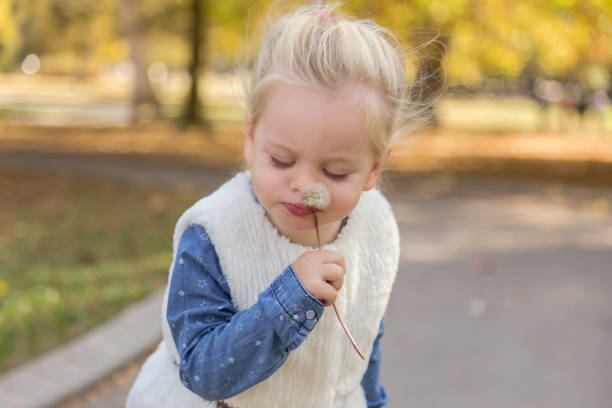 istock Cute Girl Blowing A Dandelion 1071557214