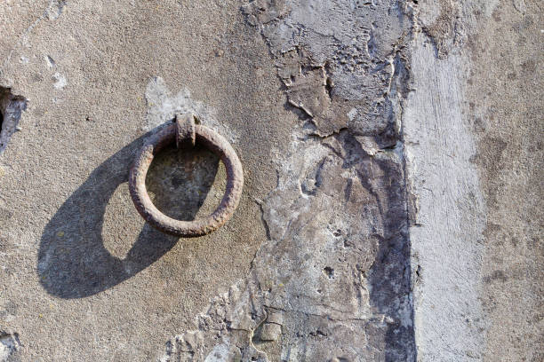 istock Old iron hoop hanging from stone wall 1071565618