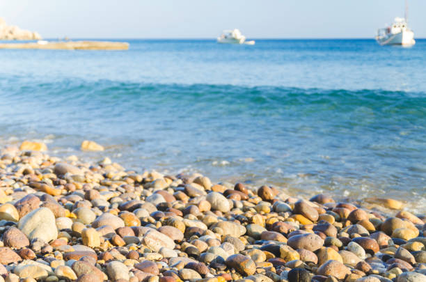 Close-up of smooth stones against the sea in Folegandros, Greece.