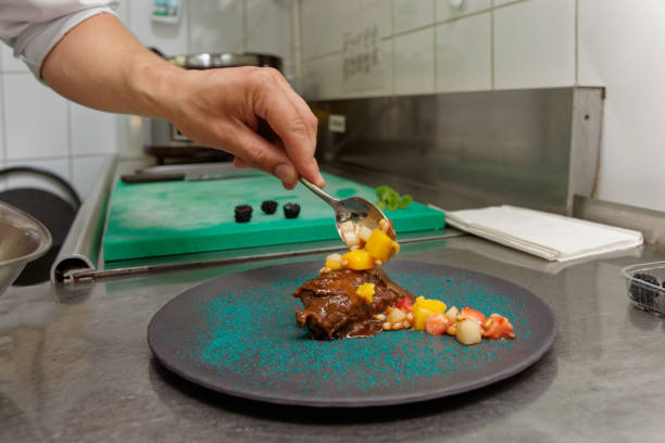 istock Chef is decorating stewed veal meat with fruit sauce 1071571112