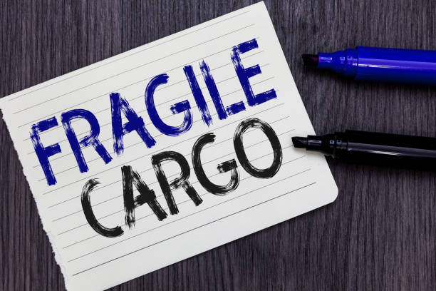istock Writing note showing Fragile Cargo. Business photo showcasing Breakable Handle with Care bubble pack Glass Hazardous Goods Notebook Paper Reminder Communicating ideas Markers Wooden background. 1071571908