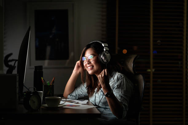 Portrait of Asian Businesswoman listening the music via headphone and smart mobile phone with glad action on the table in workplace at late time, Work hard and too late concept Portrait of Asian Businesswoman listening the music via headphone and smart mobile phone with glad action on the table in workplace at late time, Work hard and too late concept classified ad audio stock pictures, royalty-free photos & images