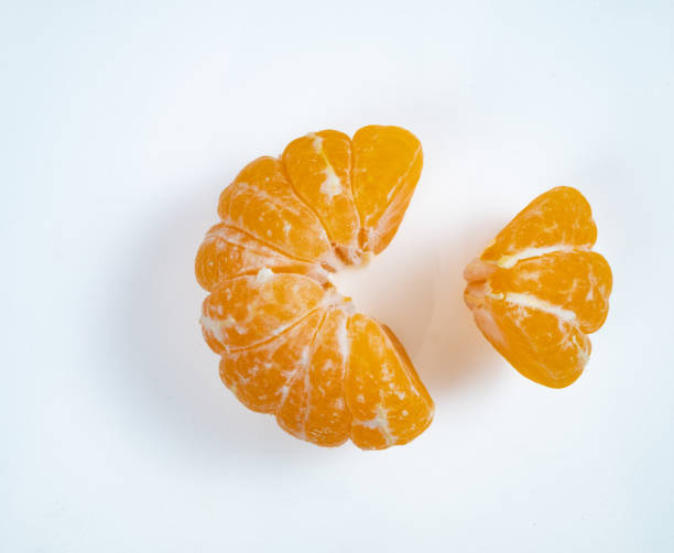 two parts of pilled mandarine. small and big one - pilled imagens e fotografias de stock
