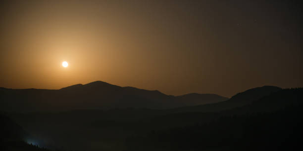 istock Panorama of mountains with full moon 1071576152