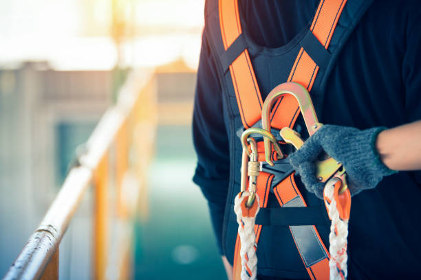 trabajador de construcción usando cinturones de seguridad y línea de seguridad en lugar alto - ropa protectora deportiva fotografías e imágenes de stock