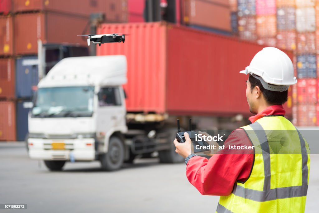 Foreman control drone to fly to survey the area worth in container yard Drone Stock Photo