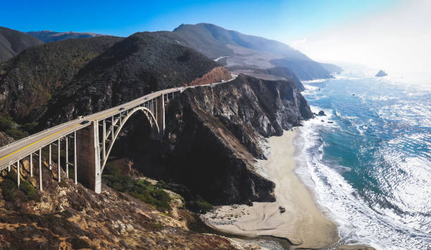 panoramische luftaufnahme des historischen bixby creek bridge entlang welt berühmten pacific coast highway 1 in sonnigen sommertag, monterey county, kalifornien, usa, gedreht von drohne - coastline big sur california pacific ocean stock-fotos und bilder