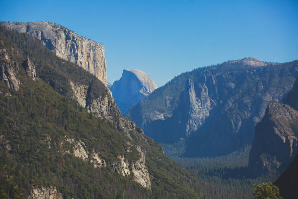 beautiful summer view of yosemite valley , with el capitan mountain, half dome mountain, bridalveil waterfall, seen from tunnel view vista point, yosemite national park, california, usa - mist mountain range californian sierra nevada cliff imagens e fotografias de stock