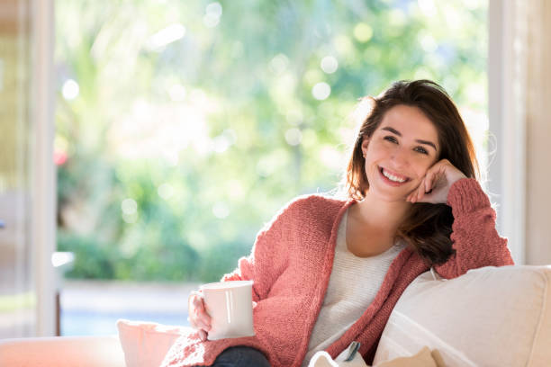istock Young woman smiles confidently while relaxing at home 1071595180
