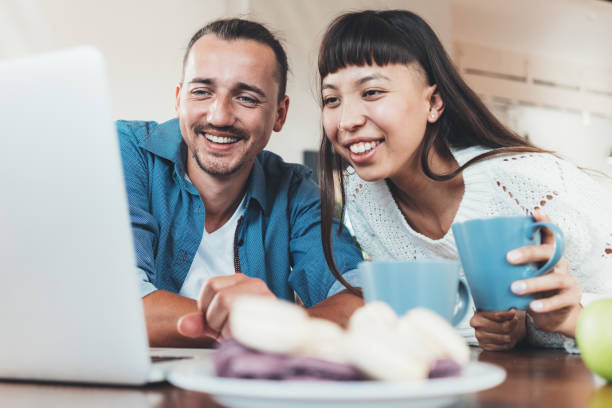 istock Happy couple sitting together with laptop 1071597554