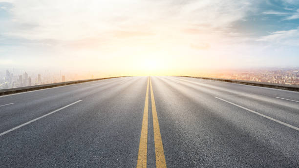 istock Panoramic city skyline and buildings with empty road at sunset 1071599298